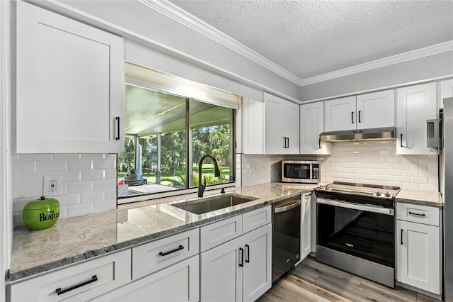 16 Courtney Pl, Palm Coast, FL 32137 - kitchen with stainless steel appliances, a textured ceiling, backsplash, ornamental molding, and white cabinets