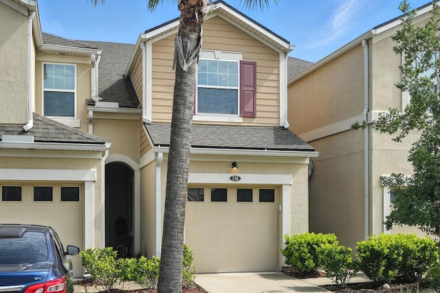 176 Nelson Ln, Saint Johns, FL 32259 - view of front facade with a garage, a shingled roof, stucco siding, and concrete driveway