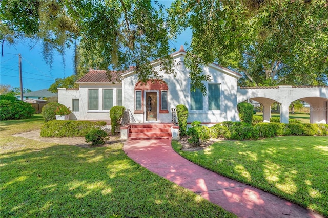 mediterranean / spanish home with a front yard