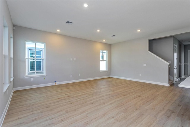 empty room with light wood finished floors, visible vents, and recessed lighting