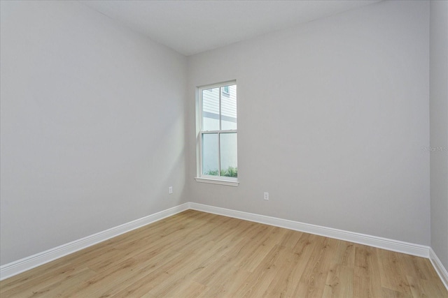 spare room featuring light wood-style floors and baseboards