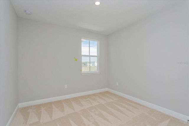 spare room with recessed lighting, baseboards, and light colored carpet