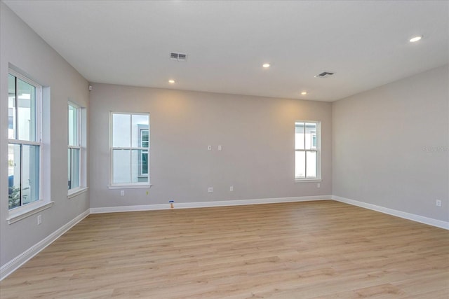 unfurnished room with baseboards, visible vents, and light wood-style floors