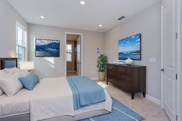 bedroom with light carpet, baseboards, multiple windows, and visible vents