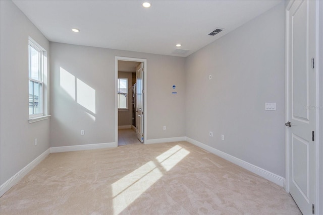 empty room with recessed lighting, visible vents, and light colored carpet