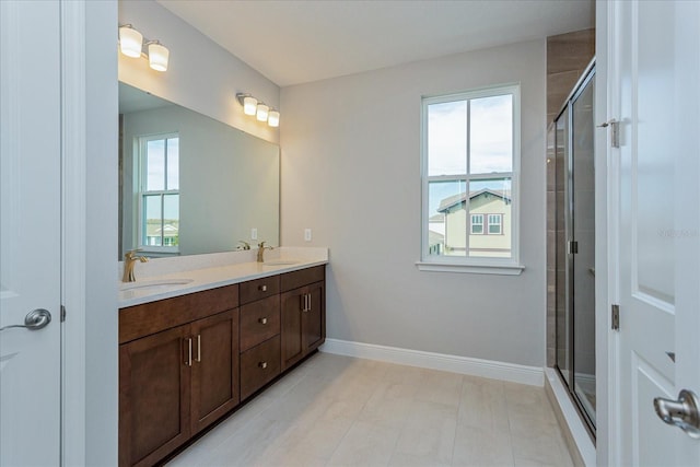 bathroom with plenty of natural light, a sink, baseboards, and double vanity