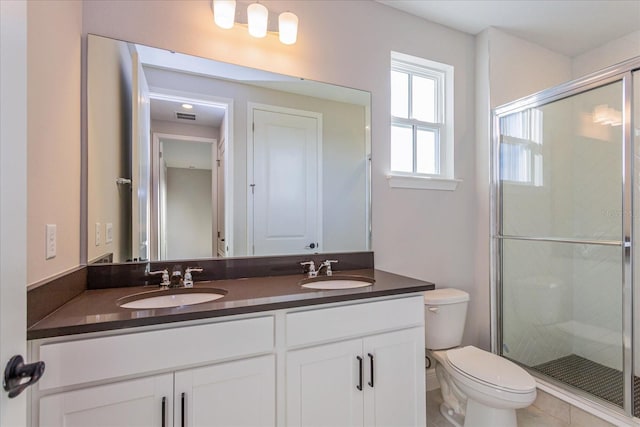 full bathroom with a sink, a shower stall, toilet, and double vanity