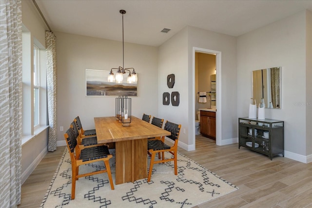 dining area featuring a chandelier and light wood-type flooring