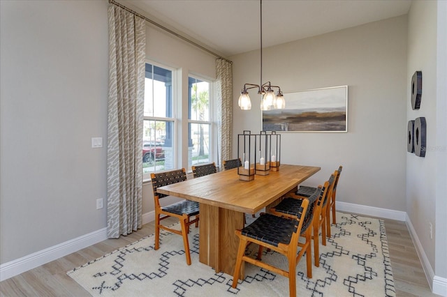 dining space with a chandelier and light hardwood / wood-style flooring