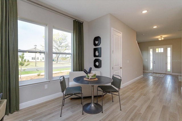 dining room with light wood-type flooring and a wealth of natural light