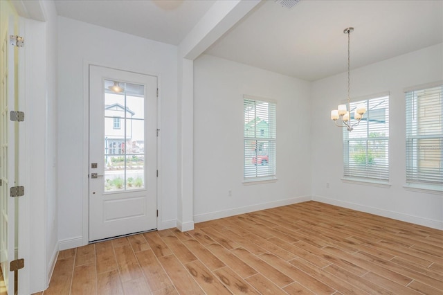 entryway featuring an inviting chandelier, light hardwood / wood-style floors, and a healthy amount of sunlight