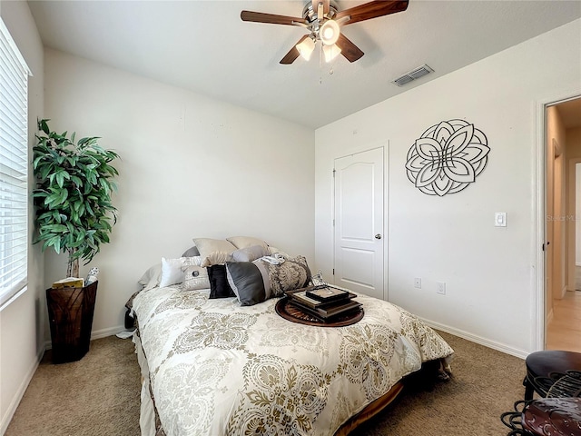 carpeted bedroom with multiple windows and ceiling fan