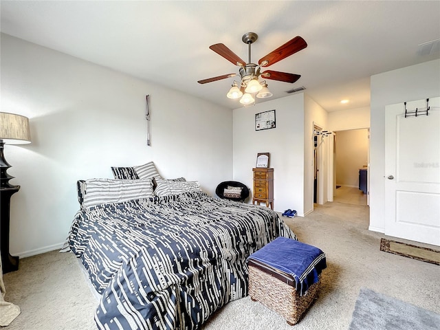 bedroom with connected bathroom, ceiling fan, and light colored carpet