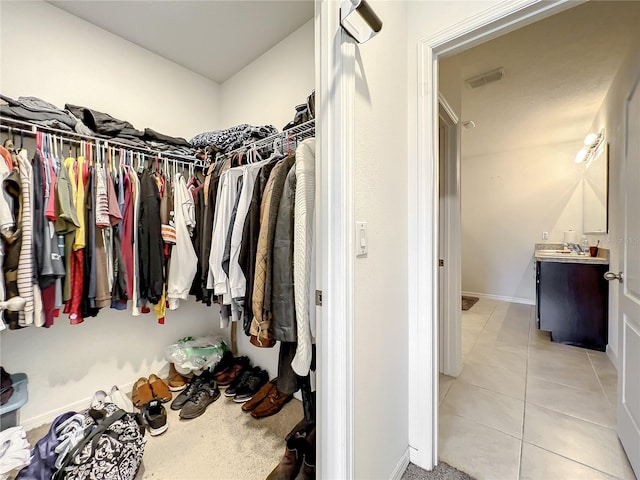 walk in closet with sink and light tile floors