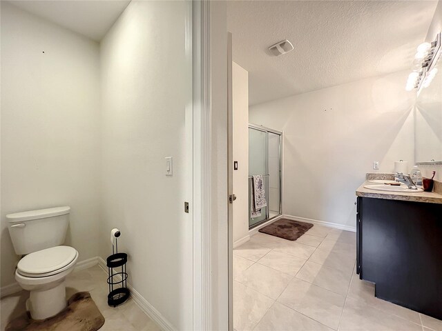 bathroom featuring tile floors, oversized vanity, a shower with shower door, and toilet