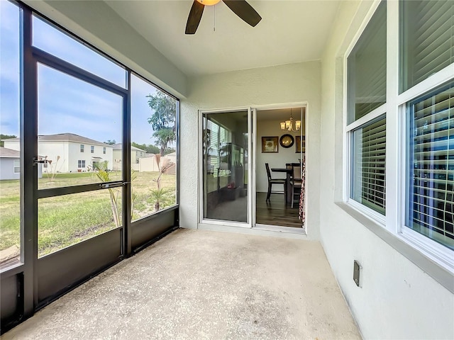 unfurnished sunroom with plenty of natural light and ceiling fan with notable chandelier