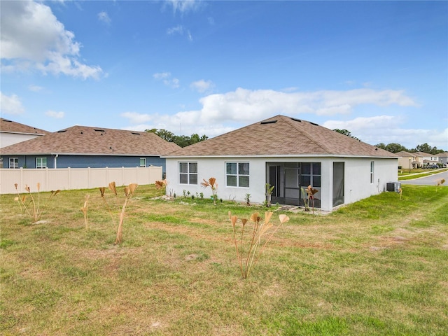 back of house featuring central AC and a yard