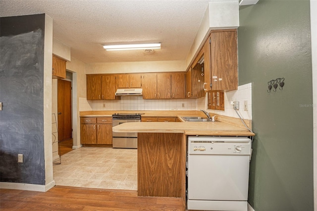 kitchen featuring light hardwood / wood-style floors, sink, stainless steel range, a textured ceiling, and dishwasher