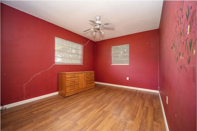 spare room with hardwood / wood-style floors, a textured ceiling, and ceiling fan