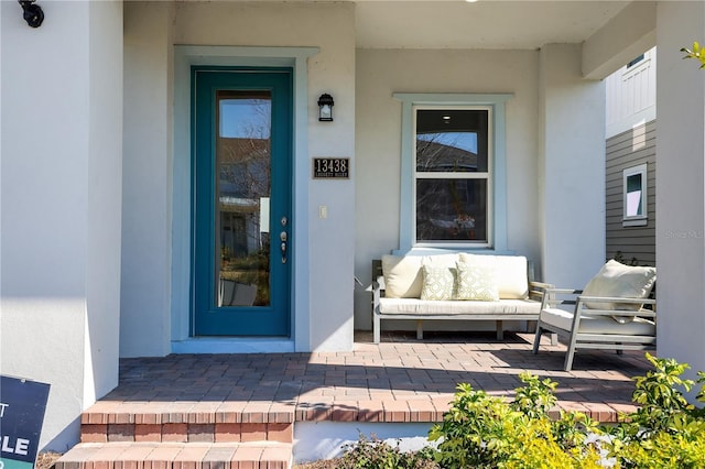 property entrance with an outdoor living space and a patio area