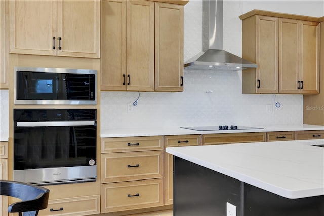 kitchen featuring wall chimney exhaust hood, stainless steel appliances, light brown cabinetry, and decorative backsplash