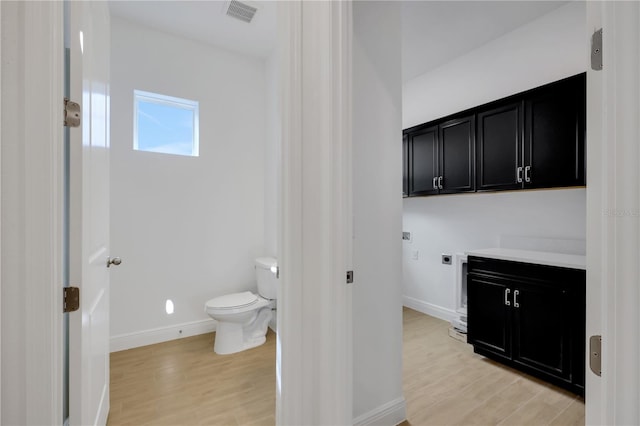 bathroom with vanity, wood-type flooring, and toilet