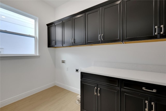 washroom featuring cabinets, electric dryer hookup, washer hookup, and light wood-type flooring