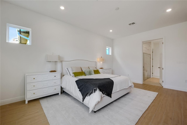 bedroom with multiple windows and light wood-type flooring