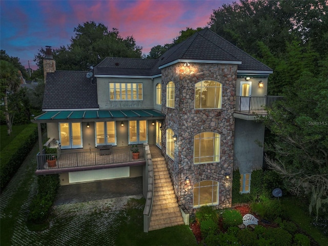 back house at dusk with a balcony