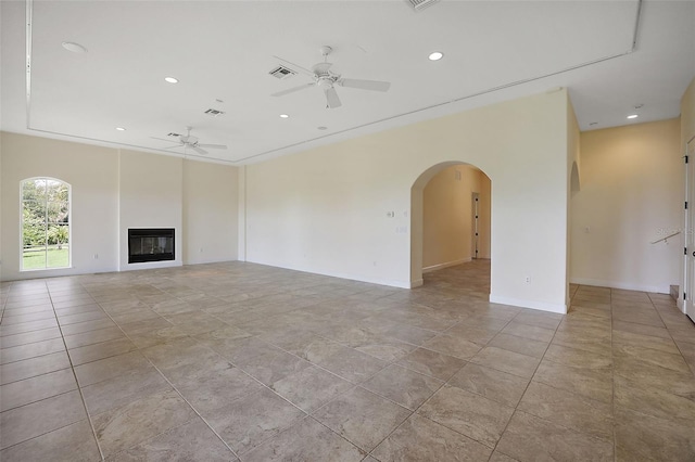 unfurnished living room featuring light tile flooring and ceiling fan