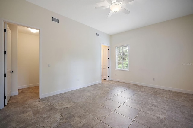 tiled spare room with ceiling fan