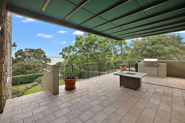 view of patio featuring grilling area, an outdoor kitchen, and an outdoor fire pit