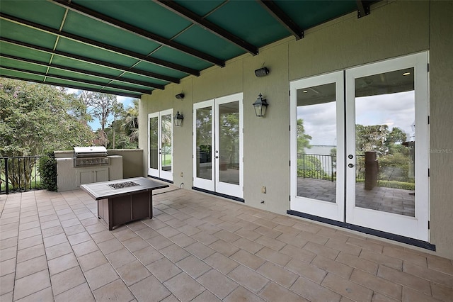 view of terrace with french doors, an outdoor fire pit, and a grill