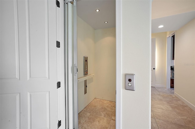 hallway featuring light tile flooring and elevator