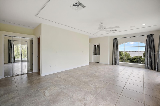 tiled empty room featuring ceiling fan