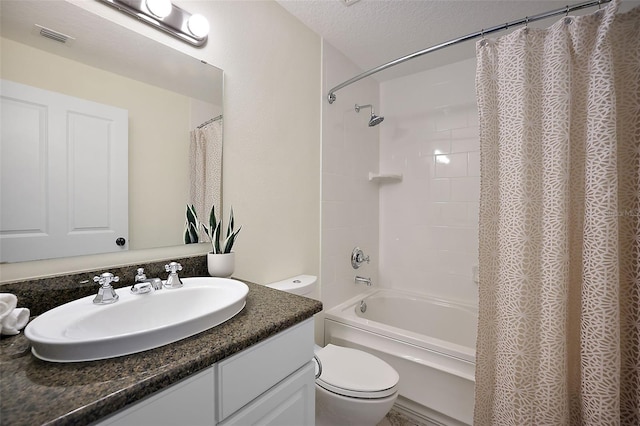 full bathroom featuring shower / bath combo with shower curtain, toilet, vanity with extensive cabinet space, and a textured ceiling