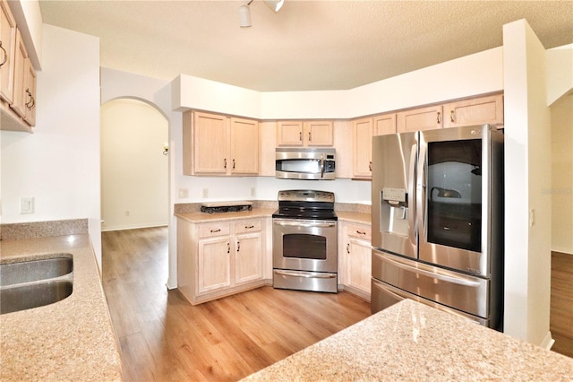 kitchen featuring light hardwood / wood-style floors, light brown cabinetry, and appliances with stainless steel finishes