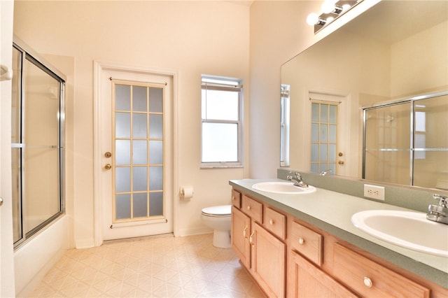 full bathroom with vanity, bath / shower combo with glass door, and toilet