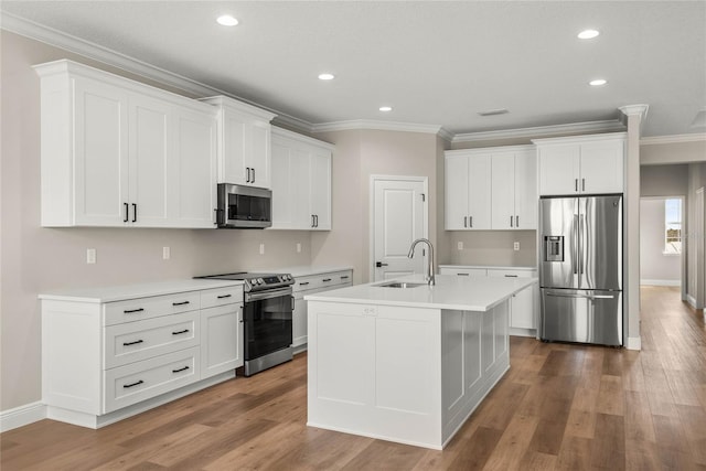 kitchen featuring an island with sink, hardwood / wood-style floors, stainless steel appliances, and white cabinetry