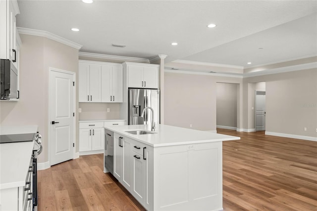 kitchen featuring crown molding, a center island with sink, stainless steel appliances, white cabinetry, and light wood-type flooring