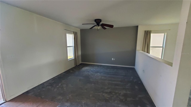 unfurnished room featuring a healthy amount of sunlight and ceiling fan