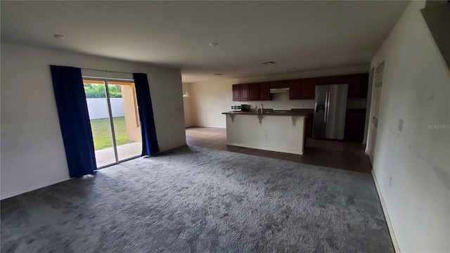 unfurnished living room with dark carpet