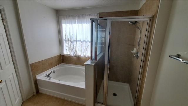 bathroom featuring shower with separate bathtub and tile flooring