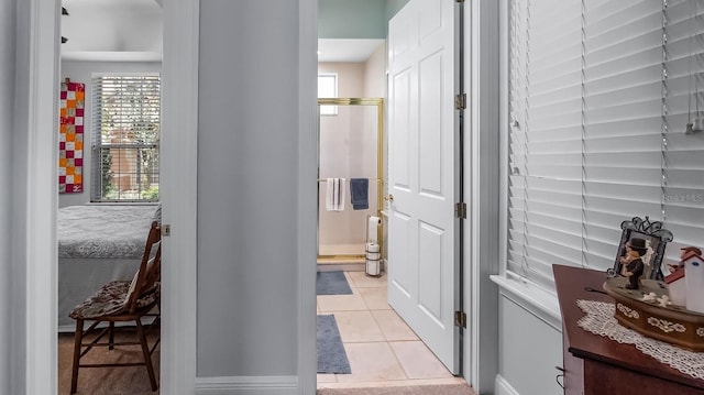 hallway with a healthy amount of sunlight and light tile patterned flooring