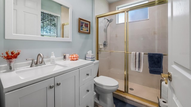 bathroom featuring vanity, an enclosed shower, and toilet