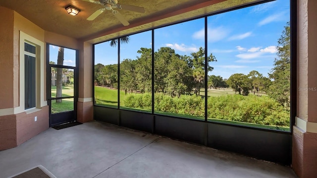 unfurnished sunroom featuring ceiling fan