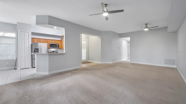 unfurnished living room featuring ceiling fan and light carpet