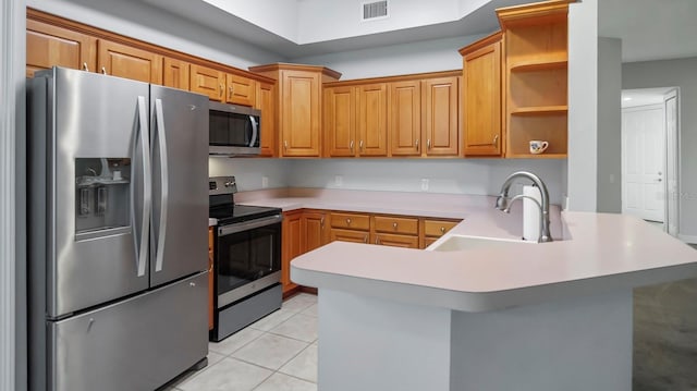 kitchen featuring appliances with stainless steel finishes, kitchen peninsula, sink, and light tile patterned floors