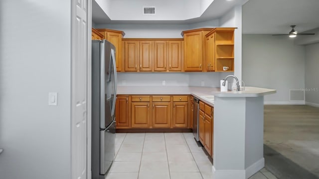 kitchen featuring sink, light tile patterned floors, kitchen peninsula, ceiling fan, and stainless steel appliances