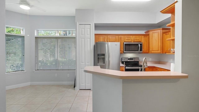 kitchen featuring ceiling fan, stainless steel appliances, kitchen peninsula, and light tile patterned floors